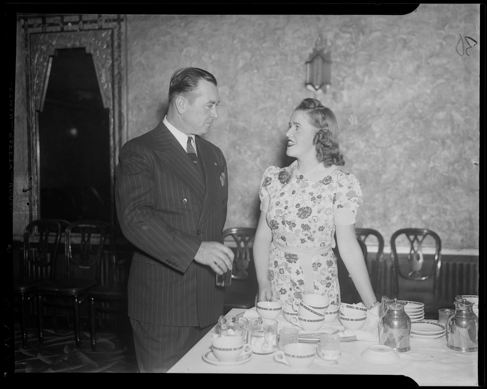 A woman and man talking near a dining table