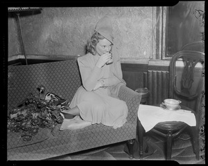 Sonja Henie on the couch, drinking