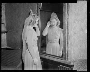 Sonja Henie looking in the mirror, primping her hair