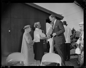 George C. Lodge shaking hands with a woman