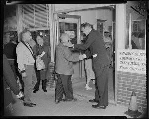 George C. Lodge shaking a man's hand as he walks into the Raytheon Missile and Space Division Andover Plant building