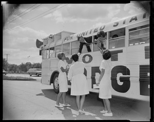 George C. Lodge hanging out of the bus window to shake hands with a women