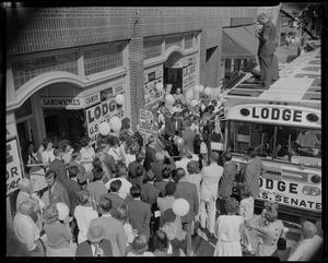 Group gathered outside of a store with Lodge for U.S. Senator posters