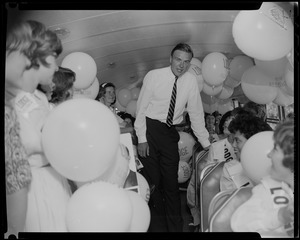 George C. Lodge talking to people seated on a bus