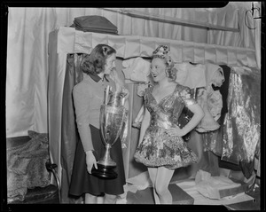 Sonja Henie and Mary Burke with trophy, in a dressing room