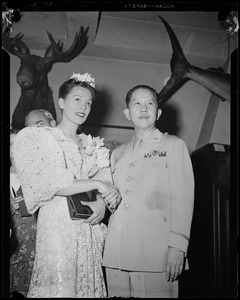 Man in military uniform shaking hands with a woman
