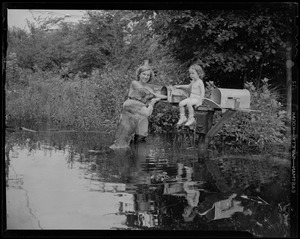 Woman, child and dog getting the mail in the flooded waters