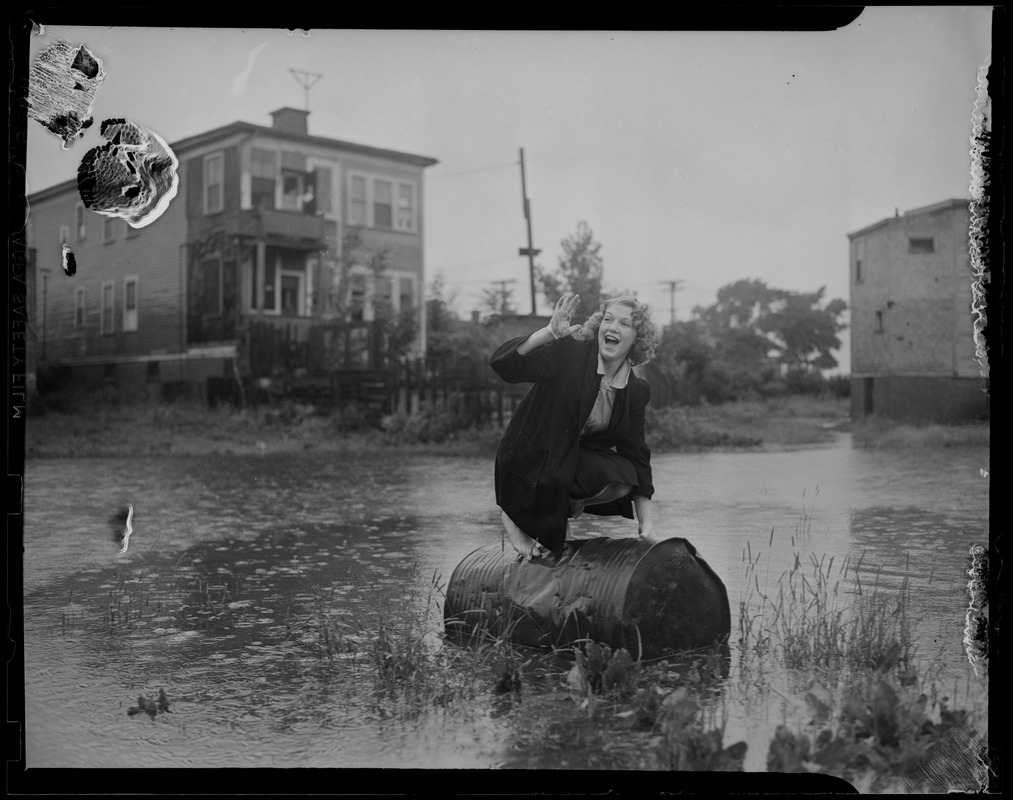 Woman on a barrel in flooded area