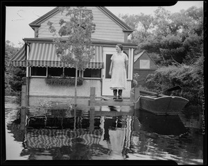 Woman standing on front porch with the water level nearly parallel