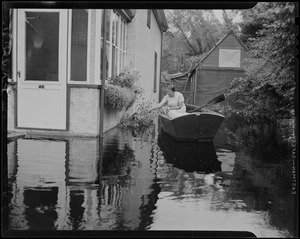 Woman in boat, assessing floral around home