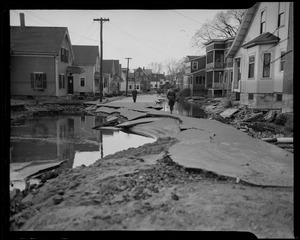 Uniformed officer walking down damaged and flooded street