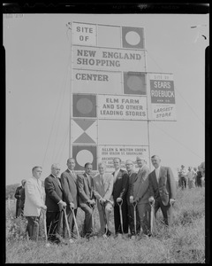 Smaller group of men, all with shovels, in front of The Site of New England Shopping Center sign