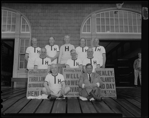 Group photo of 1914 Harvard Crew team posing with Evening News posters and Senator Leverett Saltonstall