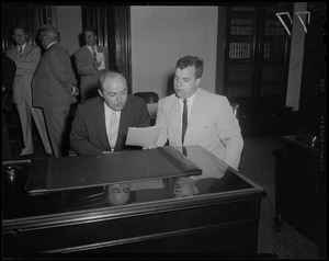 Two men at a desk reviewing a document