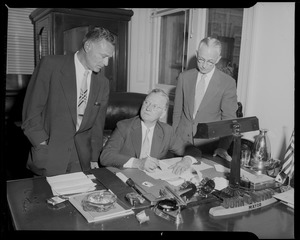 City Clerk Walter J. Malloy, right, and Atty. Joseph J. Gottleib, representing Sears Roebuck, look on after Mayor Hynes signs the bill authorizing the sale of city-owned land in Fenway to Sears Roebuck and Co.