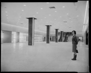 Woman standing in foyer of War Memorial Building, with escalator at the end