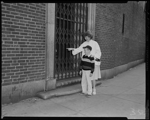 Woman pointing something out to a young boy outside of the Charles St. Jail