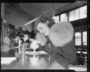 Woman eating a sundae at the diner counter of a Howard Johnson's