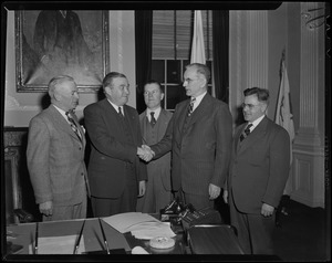 Governor Dever shaking hands with J.W. McCormack while other men look on at an office in New Haven