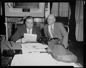 Governor Dever going through a document with John F. Stokes