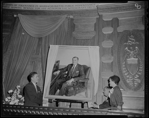 Two men pulling back the curtain to reveal the portrait of former Governor Dever while niece Marjorie Dever looks on