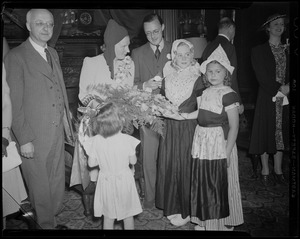 Princess Juliana and Prince Bernhard welcomed by three girls in Dutch dress and a bouquet