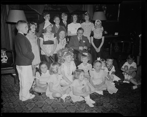 Princess Juliana and Prince Bernhard seated with a large group of children surrounding them
