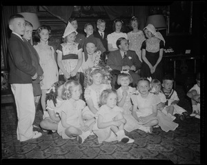 Princess Juliana and Prince Bernhard seated with a large group of children surrounding them