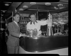 Fred Waring demonstrating a mixer as another man looks on