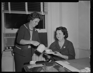Woman serving Louise Hicks coffee or tea at her desk