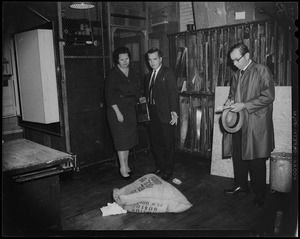 School Committee Chairman Louise Day Hicks with teacher Joseph F. Mawn, holding a flammable material can, as he points to a bag on the ground