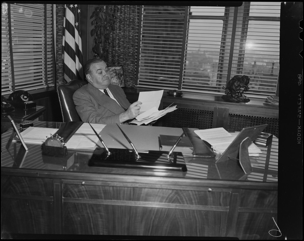 Paul Dever seated at his desk