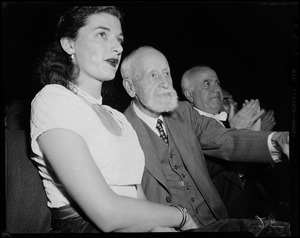 Woman and man in the audience, listening to a speaker