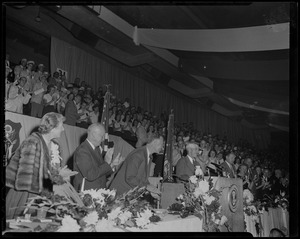 President Dwight Eisenhower and Governor Herter stand and clap as Leverett Saltonstall stands at the podium