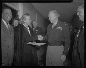 General Eisenhower shaking the hands of a woman with a fur coat