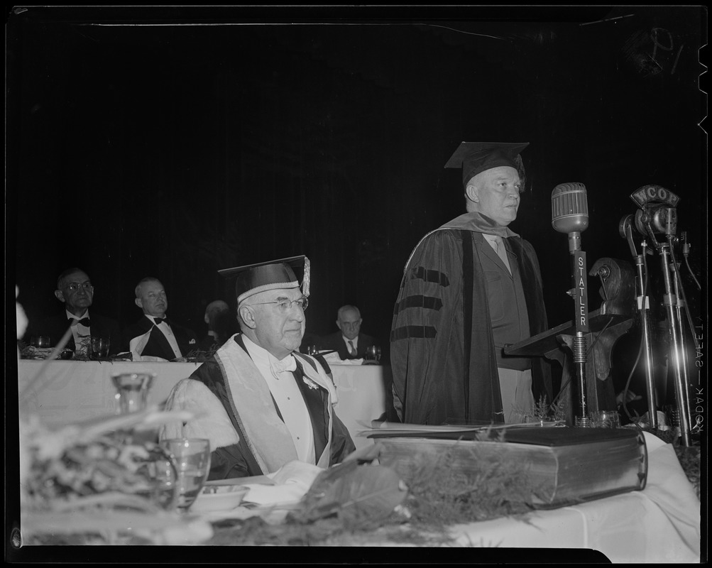General Eisenhower in robes and cap at podium with Boston University President Daniel Marsh seated at his right