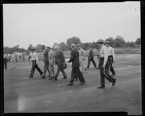 President Dwight Eisenhower walking with a group, in route to the flood in Connecticut