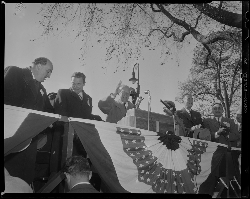 General Eisenhower waves to the crowd from a stage