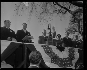 General Eisenhower waves to the crowd from a stage