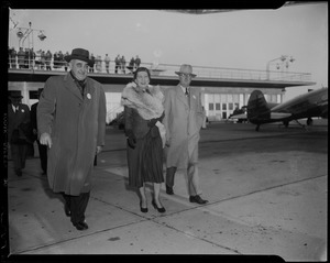 Mamie Eisenhower walking with two other men at the airport
