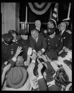 President Johnson shaking hands while police officers keep the crowd back