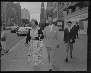 Leopold III and Lilian, Princess of Réthy, walk down the sidewalk on Newbury Street with Prince Alexandre behind them