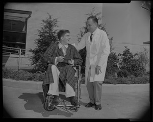 Prince Alexandre in a wheelchair, laughing with the doctor standing beside him
