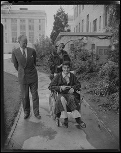 Leopold III and Lilian, Princess of Réthy, push Prince Alexandre in a wheelchair on the Children's Hospital campus