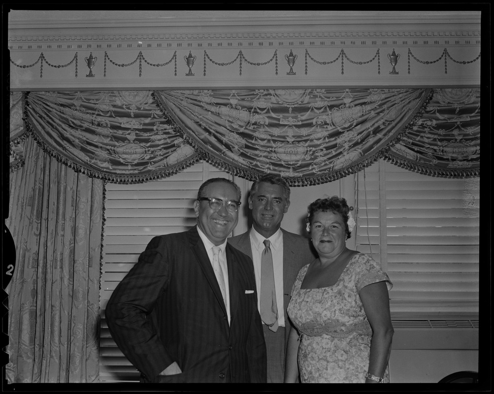 Cary Grant posing for a photo with a man and woman