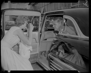 Woman taking a photo of Cary Grant, seated in a car