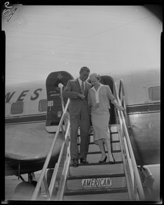 Cary Grant walking down the stairs of an American Airlines flight with stewardess Barbara Shephard