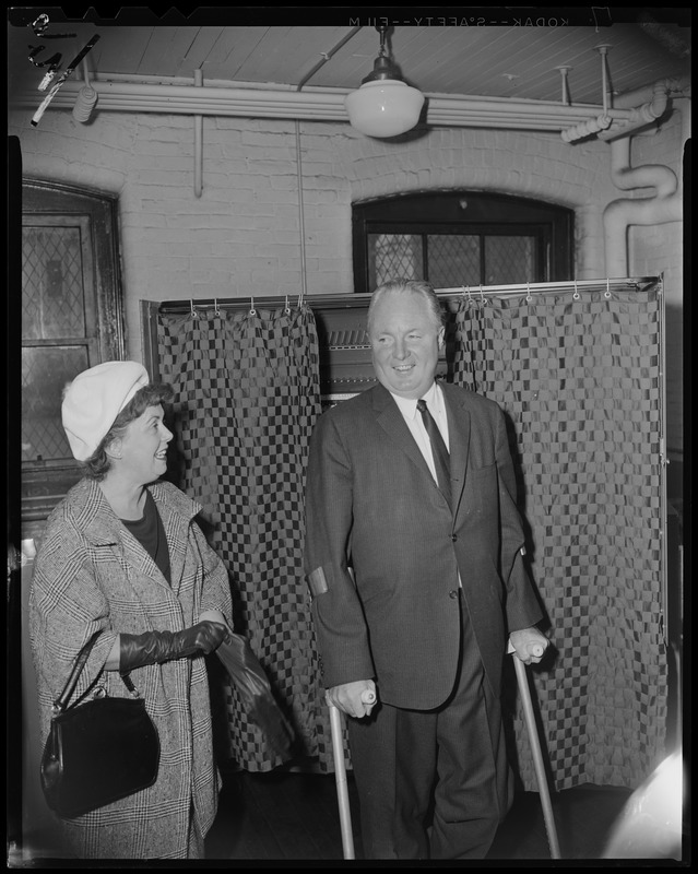 Mayor John F. Collins and his wife Mary in front of voting booth