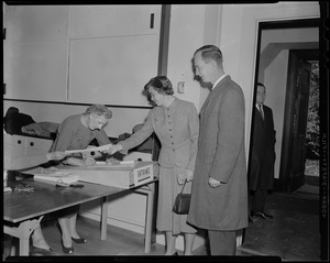 Christian A. Herter, Jr. and his wife Suzanne standing by a table in polling location