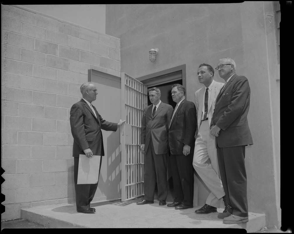 Warden John Gavin standing outside of a doorway with J. David White, George McGrath, Dr. Leon Shapiro, and Francis J. Ryrt
